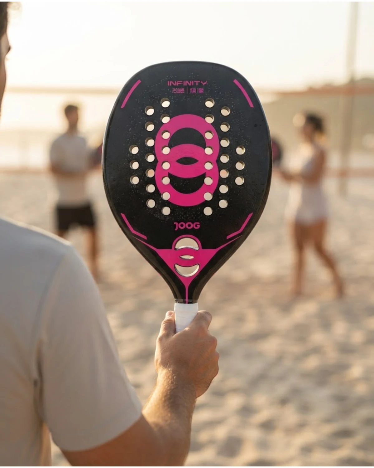 Raquete Beach Tennis Joog Infinity 3K Pro 36 Furos Preto e Fúcsia 2026 · ambientação ilustrativa na quadra